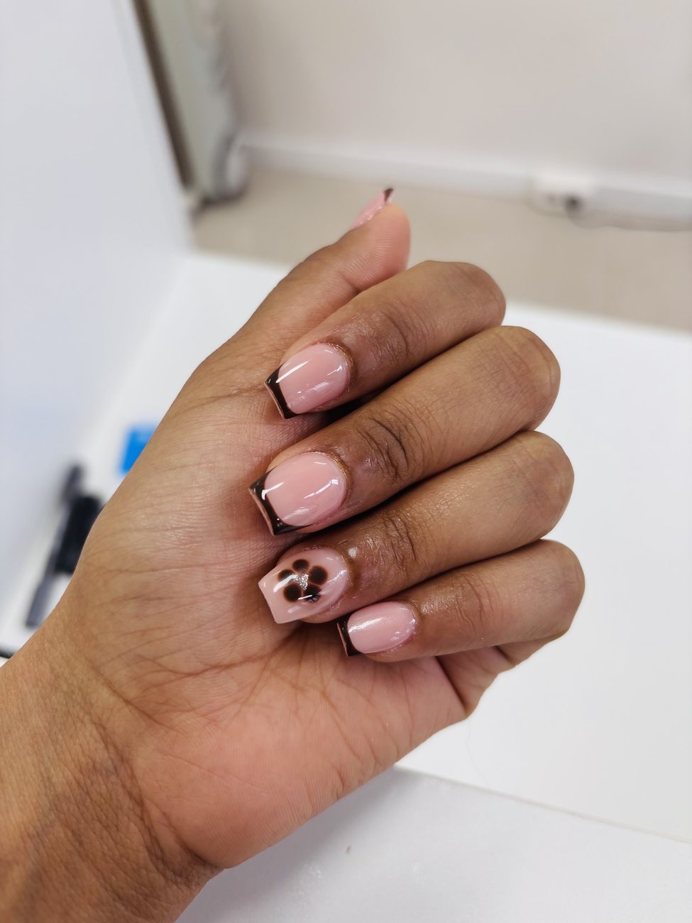 Korte nagels met donkere French tips en een panterprint op één nagel, foto van Yor
