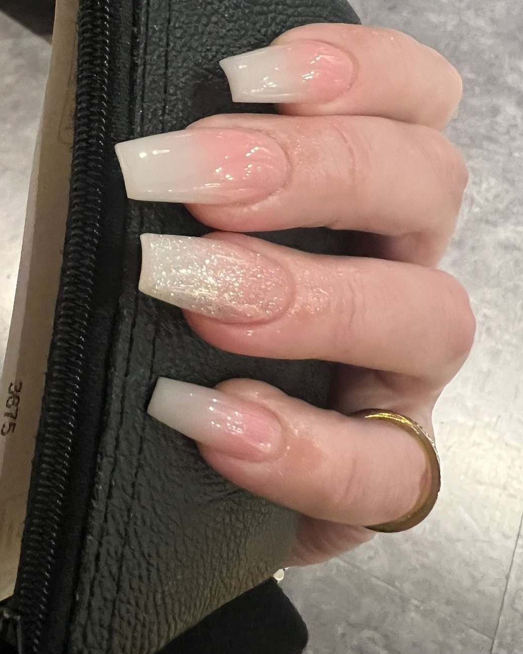 Lange vierkante nagels met een melkwitte ombre en één glitternagel